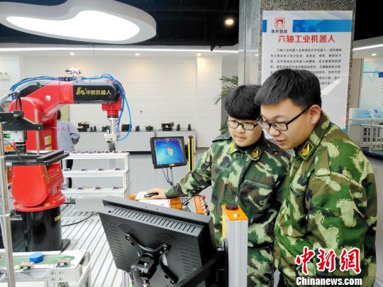 两位学员现场操作机器人。　赵桂华 摄
